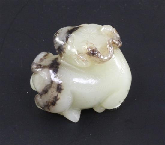 A Chinese white and black jade figure of a buffalo, in recumbent pose, 3.4cm